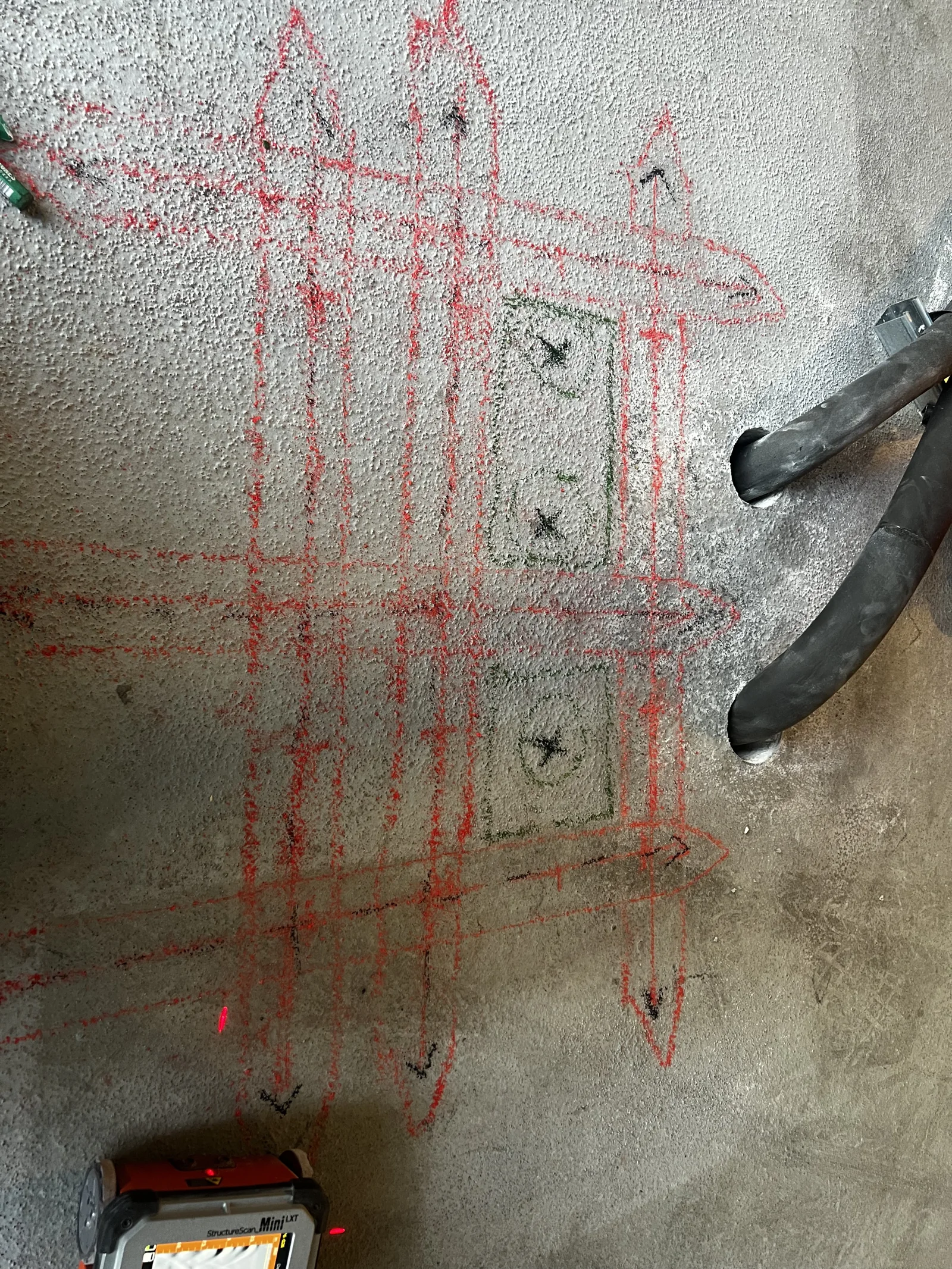 Concrete markings beside a handheld GPR scanner
